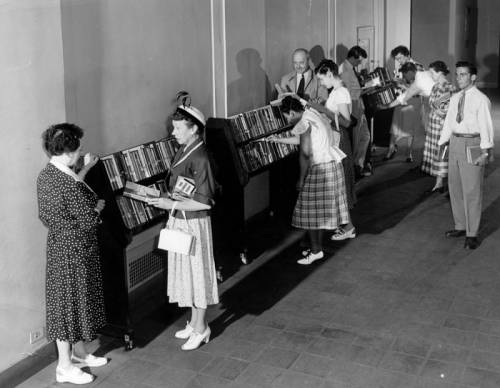 Library patrons browse the Popular Library 1950