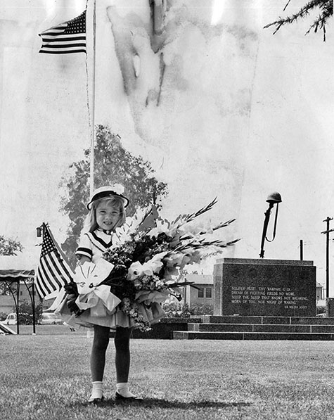 Patty Peters, 4, of Encino, carries grownup-size bouquet with flag to Veteran's Monument at Valhalla Memorial Park, North Hollywood, in observance of Memorial Day