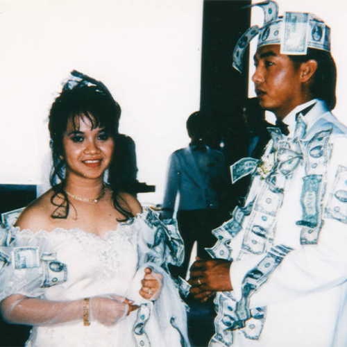 Wedding couple covered in currency during a dollar dance.