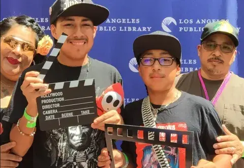 2 teens and 2 adults holding film clappers
