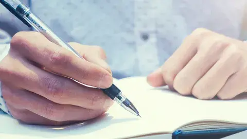 hands write something down in a journal