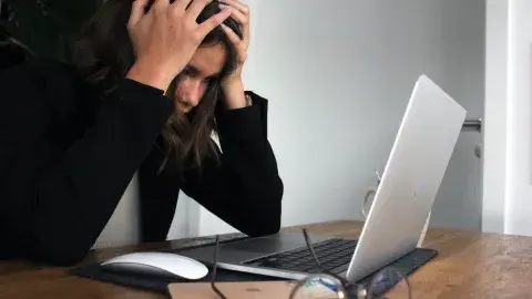 person upset looking at their laptop